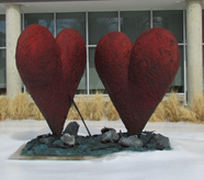 Two dark red hearts in front of a large window